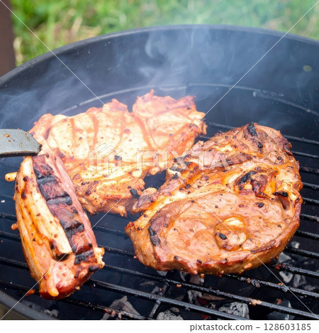 Juicy barbecue meat on the grill, close view, summer barbecue bliss background 128603185