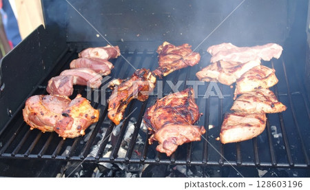 Juicy barbecue meat on the grill, close view, summer barbecue bliss background 128603196