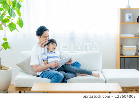 一家人在客廳看平板電腦 128604802