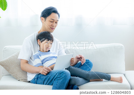 一家人在客廳看平板電腦 128604803