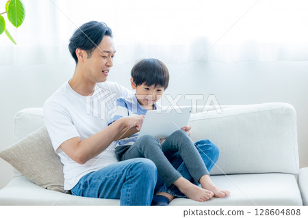 一家人在客廳看平板電腦 128604808