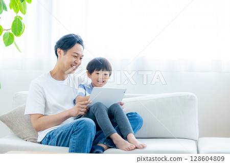 family looking at tablet in living room family looking at tablet in living room 128604809