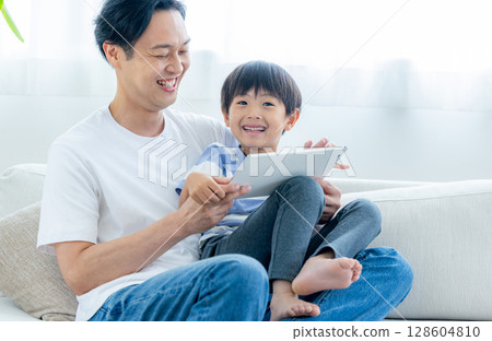 family looking at tablet in living room 128604810