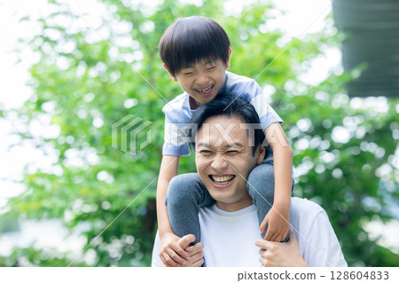 Dad carrying a child on his shoulders Dad carrying a child on his shoulders 128604833