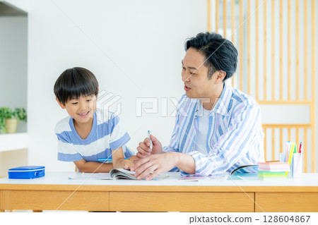 Child and father studying in the living room 128604867