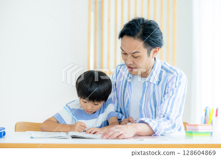 Child and father studying in the living room 128604869
