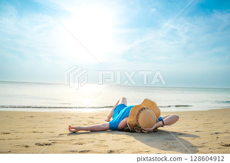 Rear View of young model lying with hat on beach at Patong beach Rear View of young model lying with hat on beach at Patong beach 128604912