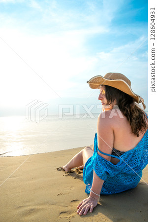 Rear view of young model observing horizon with hat on beach at Patong beach Rear view of young model observing horizon with hat on beach at Patong beach 128604931