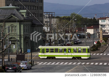 [Passengers with license plates obscured] Hakodate City Tram passing in front of the former Soma Co., Ltd. 128606596