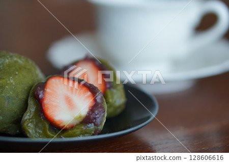 抹茶口味的草莓大福切成兩半,露出新鮮的草莓和柔滑的豆沙。 抹茶口味的草莓大福切成兩半,露出新鮮的草莓和柔滑的豆沙。 128606616