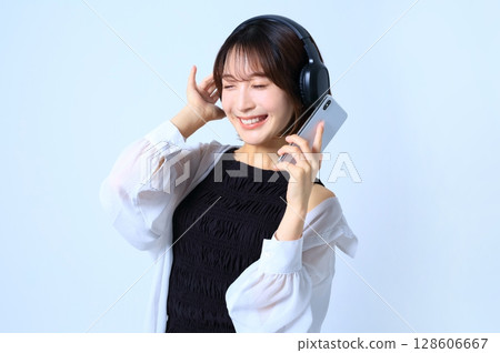 一位女士正在用智慧型手機聽音樂的圖片 128606667