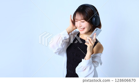 Image of a woman listening to music on her smartphone 128606670