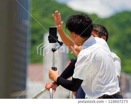 用智慧型手機播放選舉街頭演講影片的人 128607273
