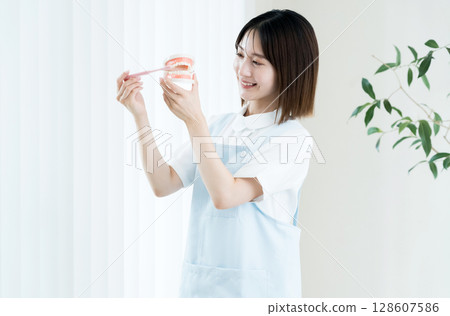 拿著牙刷和牙齒模型的牙科工作人員女士 128607586