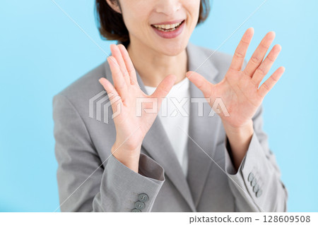 A middle-aged female business woman cheering in a suit A middle-aged female business woman cheering in a suit 128609508