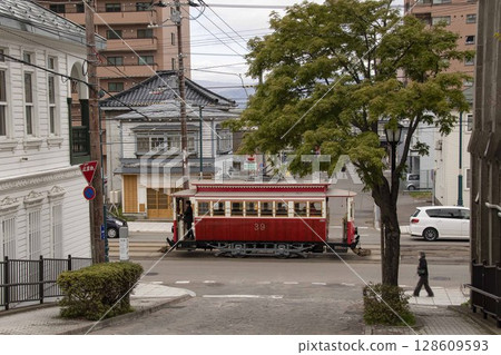 [行人模糊，乘客廣告模糊] 穿過函館市末廣町函館大三坂的路面電車 128609593