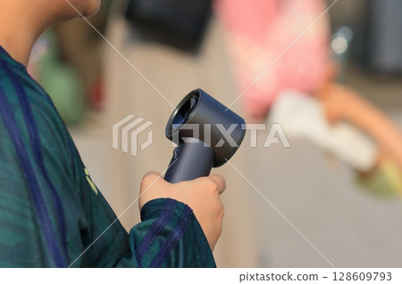 A woman walking with a handheld fan A woman walking with a handheld fan 128609793