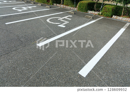 A view of a paved parking lot with spaces for people with disabilities A view of a paved parking lot with spaces for people with disabilities 128609932
