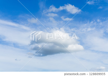 A simple scene of a white cloud floating alone in the blue sky A simple scene of a white cloud floating alone in the blue sky 128609935
