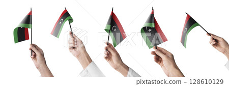 The Libya flag in hand in different angles on a white background 128610129