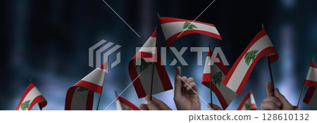 Lebanon flags in their hands on a blurred urban background 128610132