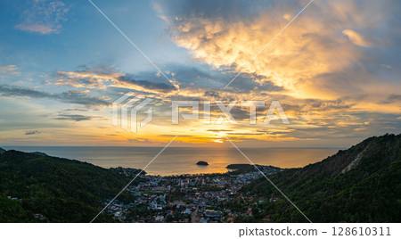 Vibrant Sunset Over Coastal Town and Hills Vibrant Sunset Over Coastal Town and Hills 128610311
