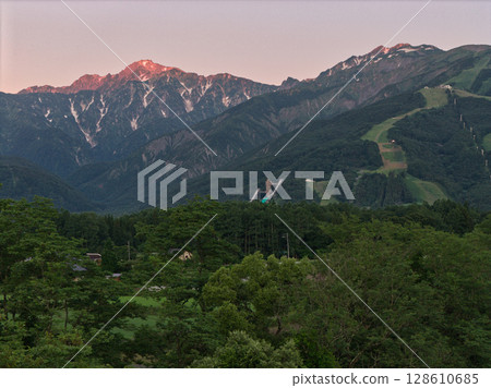 Beautiful summer morning glow at Mt. Karamatsu and Mt. Goryu in Hakuba, Nagano Prefecture (aerial shot by drone) 128610685