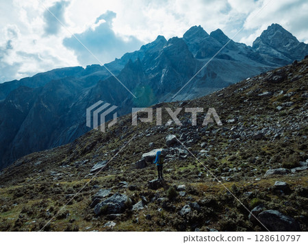 Backpacking woman climbing up on steep cliff edge at high altitude mountains top Backpacking woman climbing up on steep cliff edge at high altitude mountains top 128610797
