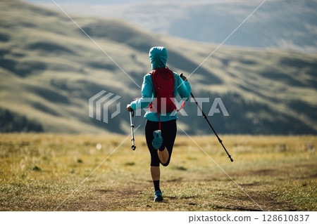 Fitness woman trail runner running in grassland mountains Fitness woman trail runner running in grassland mountains 128610837