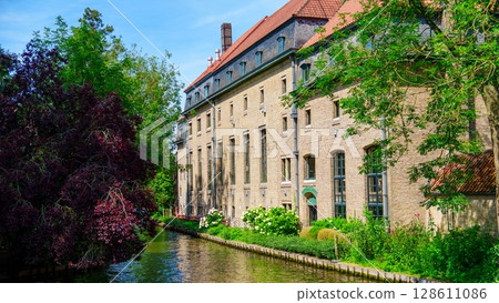 Idyllic Bruges, Belgium Canal-side view of architecture and lush greenery in Brugge, Belguim Idyllic Bruges, Belgium Canal-side view of architecture and lush greenery in Brugge, Belguim 128611086