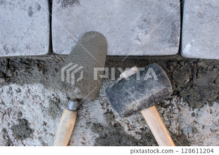 Laying paving stones on cement mortar. Laying a garden path made of tiles. Self-laying of concrete paving slabs in the courtyard of the house. do it yourself. DIY 128611204