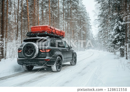 SUV with Rooftop Cargo Carrier on Snowy Road 128611558