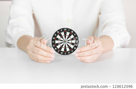 Hands Holding Dartboard Illustrating Focus, Accuracy and Protected Goal Achievement Hands Holding Dartboard Illustrating Focus, Accuracy and Protected Goal Achievement 128612096