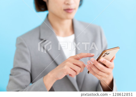 操作智慧型手機的中年女性女商人 128612851