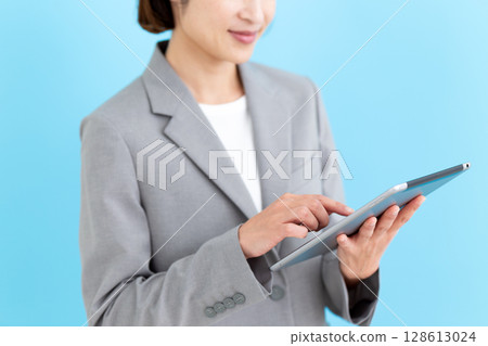 Middle-aged female business woman with tablet Middle-aged female business woman with tablet 128613024