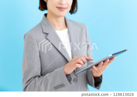 拿著平板電腦的中年女性女商人 拿著平板電腦的中年女性女商人 128613028