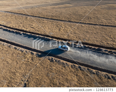 Aerial view of offroad car running on corrugated road in the remote part of Tibet, China Aerial view of offroad car running on corrugated road in the remote part of Tibet, China 128613773