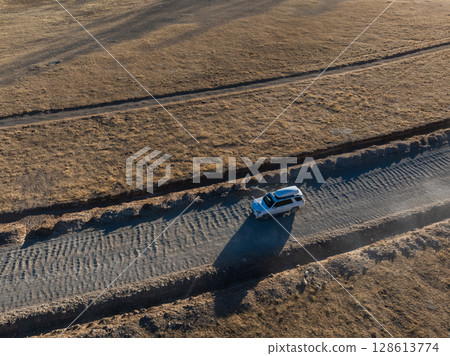 Aerial view of offroad car running on corrugated road in the remote part of Tibet, China Aerial view of offroad car running on corrugated road in the remote part of Tibet, China 128613774