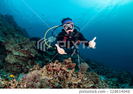 Asian female scuba diver diving looking at camera in Andaman sea, Thailand Asian female scuba diver diving looking at camera in Andaman sea, Thailand 128614048