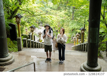 Inbound tourists praying at the torii gate 128614137