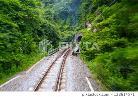 Railway tracks seen from a train running through nature 128614571