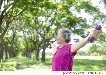 Happy Asian senior woman lifting dumbbell Happy Asian senior woman lifting dumbbell 128616342