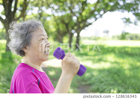 Happy Asian senior woman lifting dumbbell Happy Asian senior woman lifting dumbbell 128616343