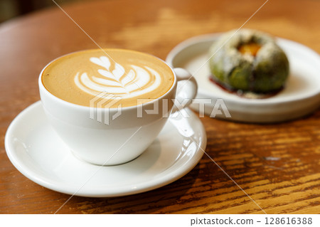Cup of hot milk latte coffee on table by the window. Cup of hot milk latte coffee on table by the window. 128616388