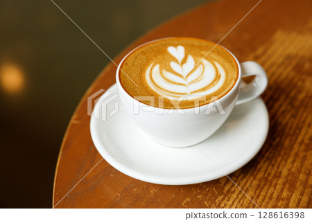 Cup of hot milk latte coffee on table by the window. 128616398