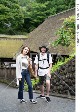 An inbound couple walking through a thatched-roofed village An inbound couple walking through a thatched-roofed village 128616481