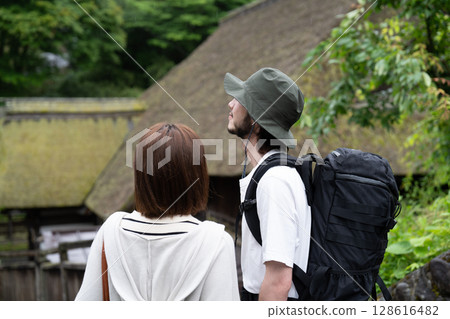 An inbound couple walking through a thatched-roofed village An inbound couple walking through a thatched-roofed village 128616482
