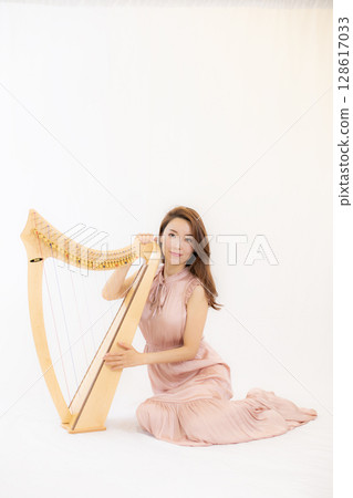 A woman who loves music and a small harp 128617033
