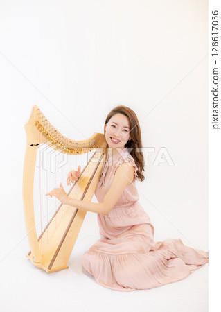 A woman who loves music and a small harp A woman who loves music and a small harp 128617036
