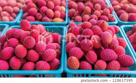 Lychee fruit in blue baskets ready for export showing processed agriculture product with vibrant red skin and fresh texture in market setting 128617395